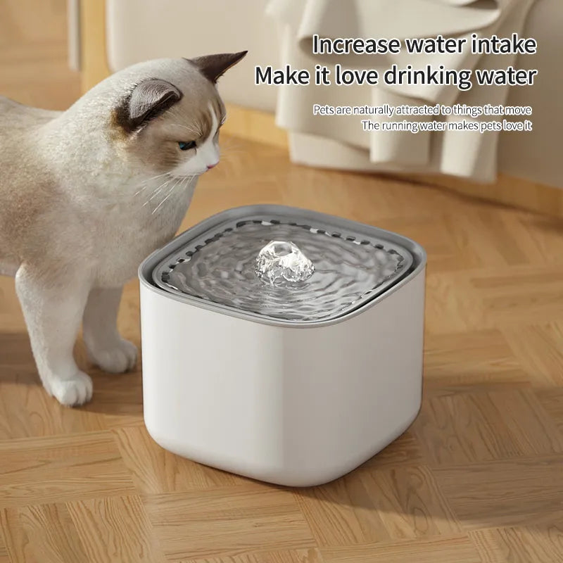 A cat looking at a white AquaPurr Refreshing Cat Water Fountain with water in it, placed on a wooden floor.