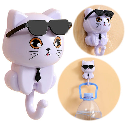 A set of images showing a cartoon cat-shaped keys hook in various states of wearing sunglasses and a tie, demonstrating its use as a home organizer by holding items such as a bottle and a towel.