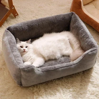 A white cat resting inside a gray CozyCat bed with a soft, plush appearance, placed on a white furry surface.