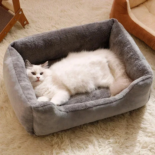 A white cat resting inside a gray CozyCat bed with a soft, plush appearance, placed on a white furry surface.
