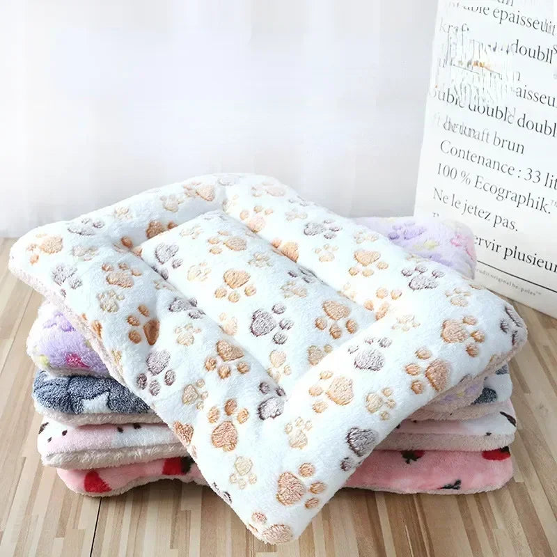 A stack of plush pet bed mats with a design of paw prints and various colors including pink and purple, indicating a soft, comforting texture.