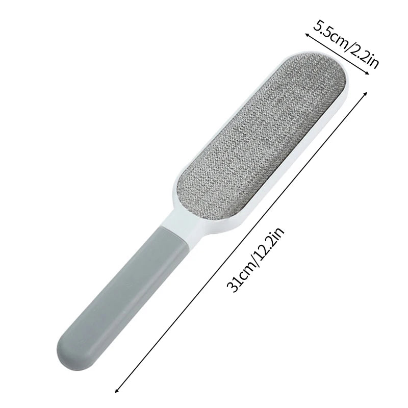 A lint roller with a white handle and a grey roller head, shown being used to remove lint and fur from a person's sweater. There are additional rollers with different colored attachments displayed beside it.