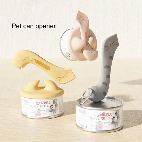 A multifunctional pet spoon and can opener designed to look like a cat. The tool is shown in two colors, beige and gray, with a silicone tip used for opening cans and scooping food.