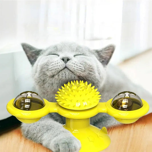 A cat interacting with a yellow and black spinning cat toy with lights.