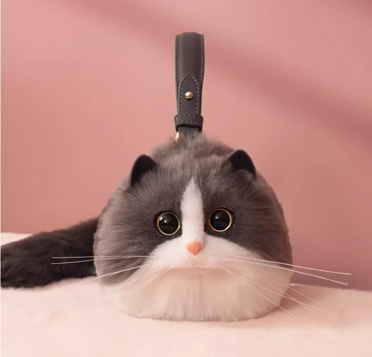 A plush toy resembling a cat with a one-shoulder bag design, featuring a soft gray and white color palette.