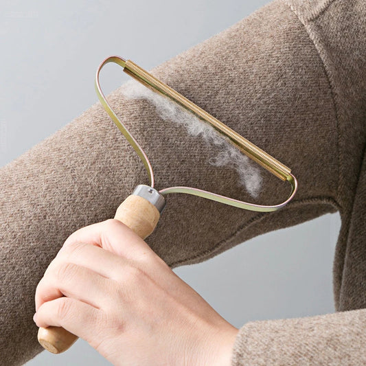 A person using a lint remover on their arm, which appears to be a pet grooming tool.