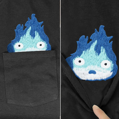 Black t-shirt with a blue and white embroidered design on the chest pocket.