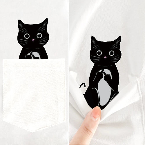 Black cat illustration on a white fabric with a hand holding it.