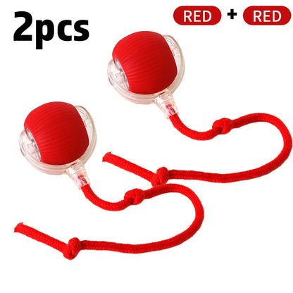 A red and clear cat interactive rolling ball toy with a faux tail, displayed with its charging cable.