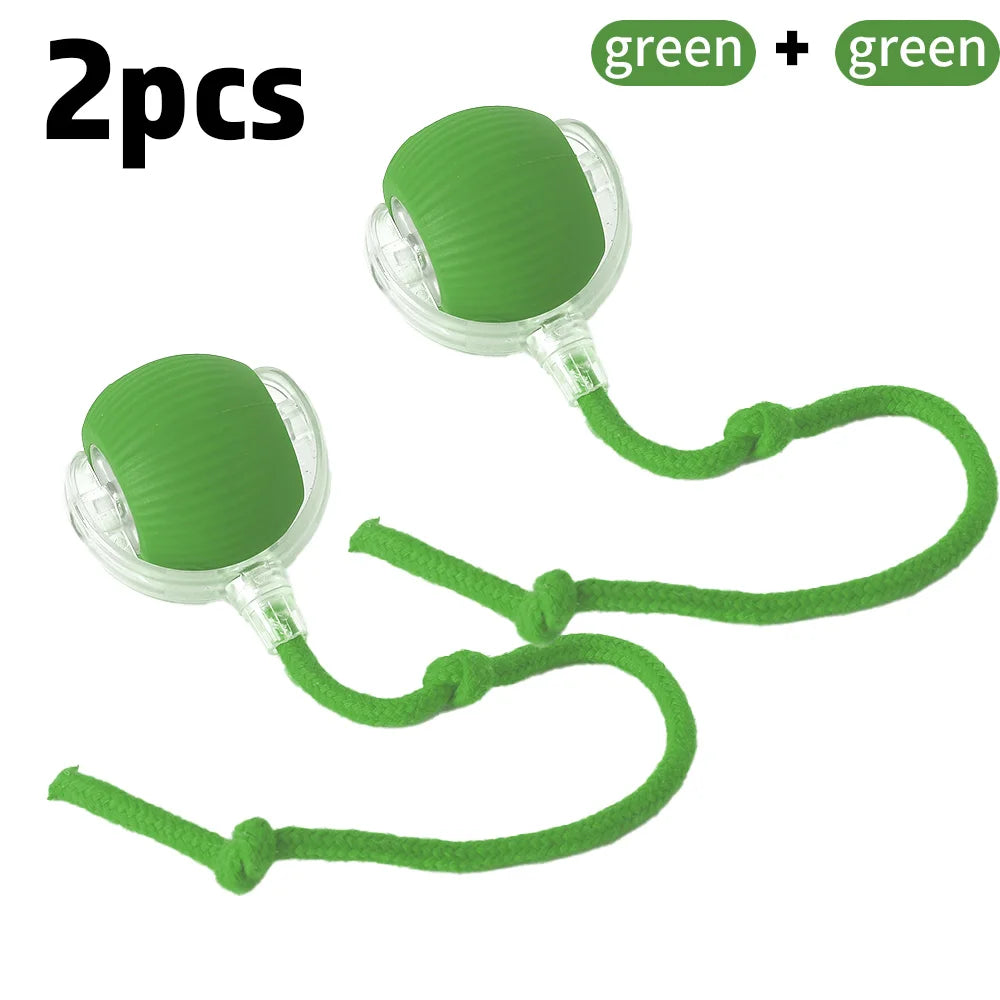 A green and clear rolling ball toy with a faux tail, designed for cats. The toy is on a string, presenting as a playful and interactive pet accessory.